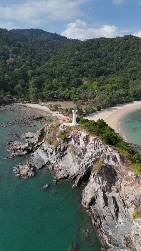 White Lighthouse Standing on Rocky Cliff Coast in Koh Lanta, Thailand Video stock 335950694