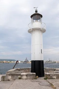 White lighthouse tower with black base is under blue sky on a daytime Stock Photos