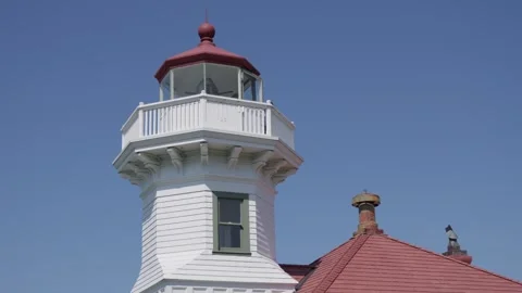 White lighthouse tower with red roof against clear blue sky 库存影片 312771953