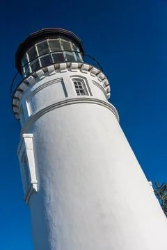 White lighthouse tower under clear blue sky, coastal landmark Stock Photos