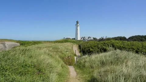 White lighthouse on a windy green hill Stock Footage 338329221