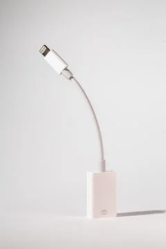 A white lightning cable is sitting on a white table Foto stock