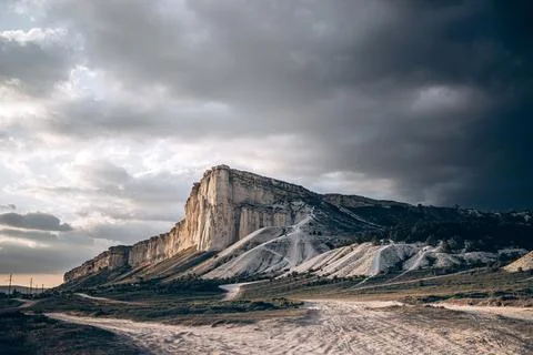 White limestone cliff under dramatic cloudy sky Stock Photos