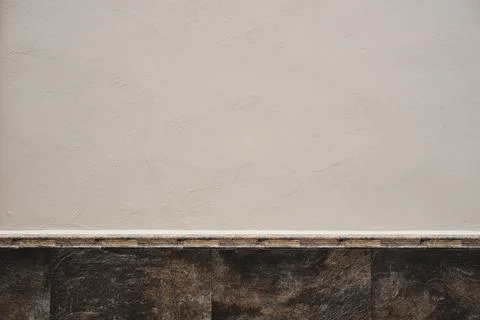 White limewash plaster wall with stone finish ceramic tile skirting board Stock Photos