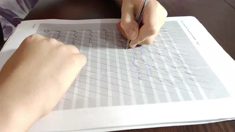 A white little child learns to write beautifully in Cyrillic Stock Footage 163839668