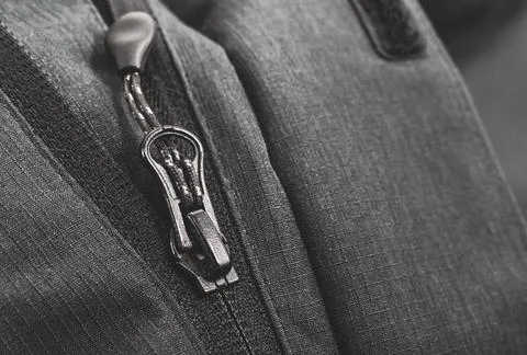 White lock with a zipper on clothes, jacket, jacket close-up on a black Stock Photos