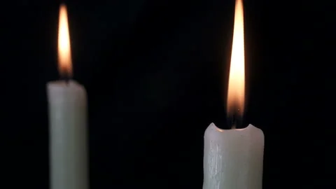 White long candle close-up. The flame of a candle slowly shakes from the air Stock-Footage 107781442
