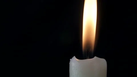 White long candle close-up. The flame of a candle slowly shakes from the air Video stock 107781672