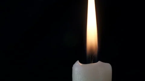 White long candle close-up. The flame of a candle slowly shakes from the air Stock-Footage 107781722