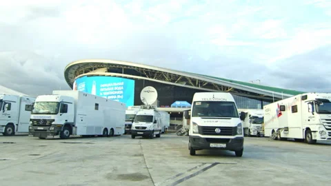 White lorries and vans with logos stand near pool building Stock Footage 237004074