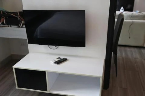 A white low table with an empty space on the top, next to it is a tv stand Stock Photos