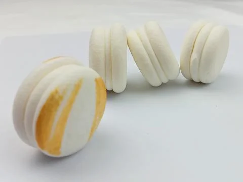 White macarons in a row isolated on white background Stock Photos