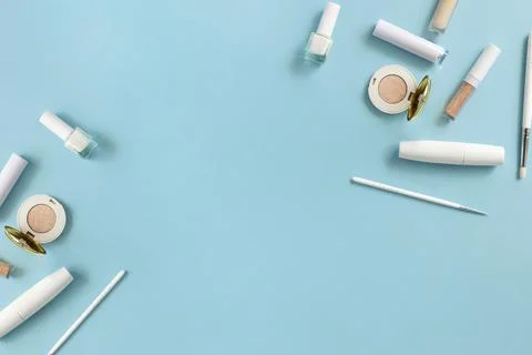 White makeup cosmetics on a blue background with copy space. On the table are Stock Photos