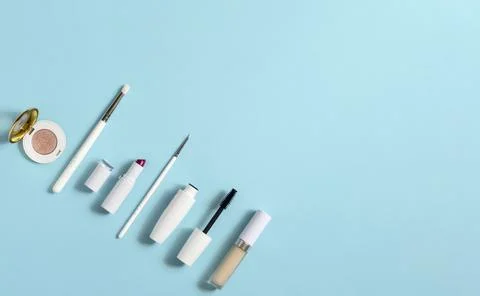 White makeup cosmetics on a blue background with copy space. On the table are Stock Photos