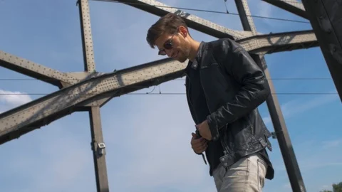 White male model taking of leather jacket an throw into camera while balancing Stock Footage 87260838