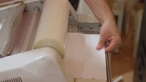 White male working with roll laminator. Stock Footage 80458689