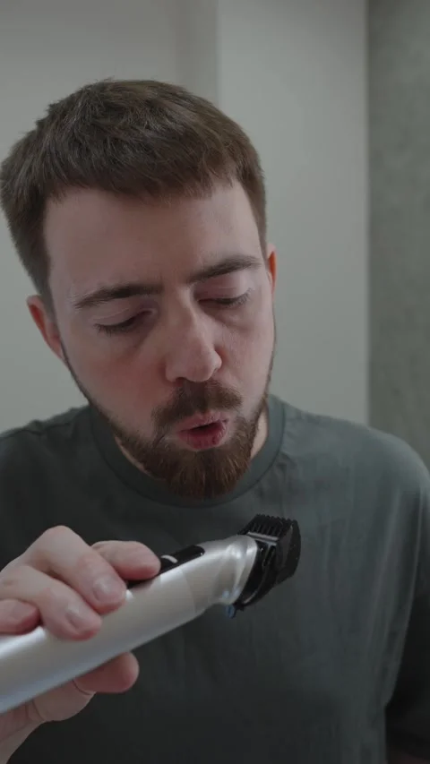 White man blowing off trimmer dust and admiring beard creative director 動画素材 333332089