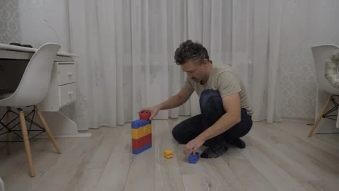 White man building colorful block tower Stock Footage 337799873