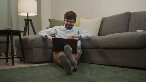 A white man communicates by video link while sitting on the floor Stock Footage 154914597