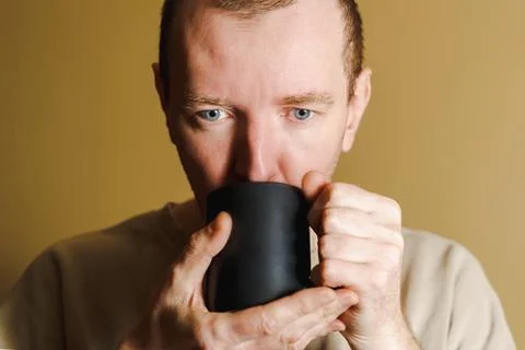 White man drinking from a cup, close-up, Portrait of a man drinking coffee from Stock Photos