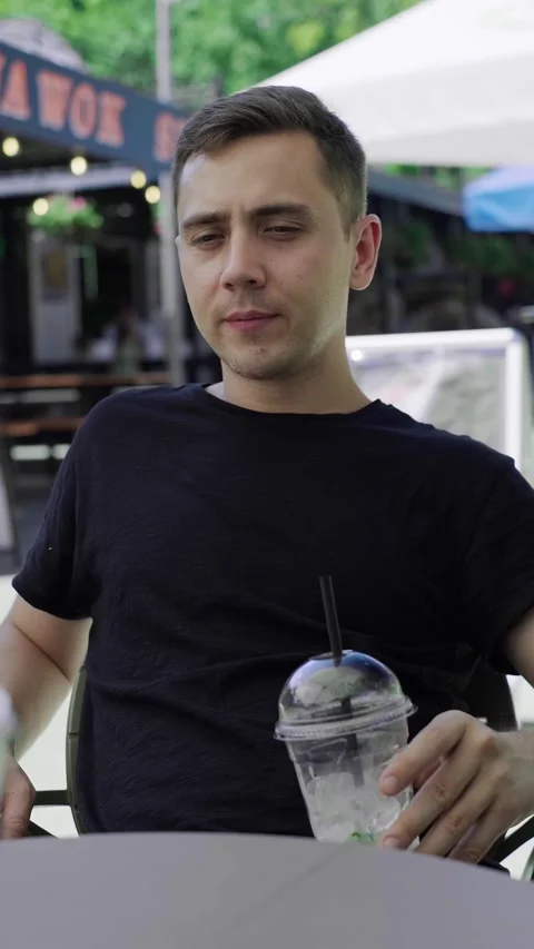 White man drinking a refreshing cocktail, outdoor café Stock Footage 279163965