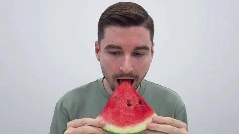 White Man eating a slice of watermelon. Tasty red watermelon with black seeds Stock Footage 282671239