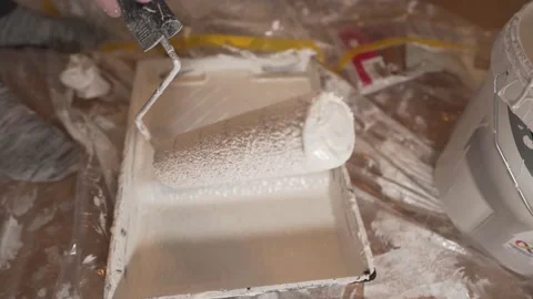 White man hand extending white paint on tray with painting roller handle Vidéo 148153717
