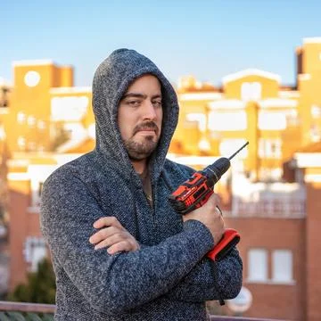White man looking at the camera with an electric drill of batteries without Stock Photos