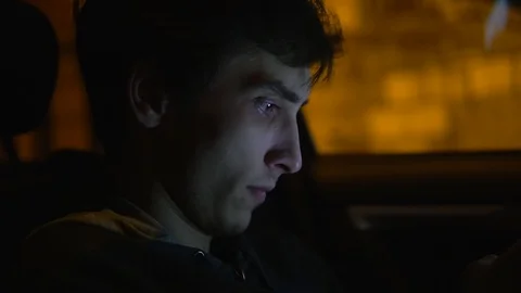White man looks into the phone while sitting in car, is surprised passing car Stock Footage 108490277
