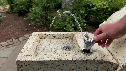 White man opens tap of drinking fountain in Tbilisi city park Stock Footage 285250502