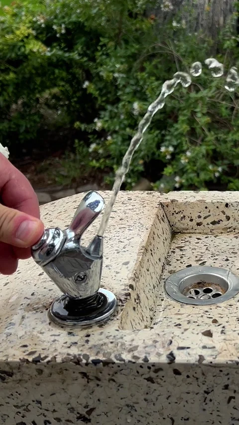 White man opens tap of drinking fountain in Tbilisi city park Stock Footage 290152573