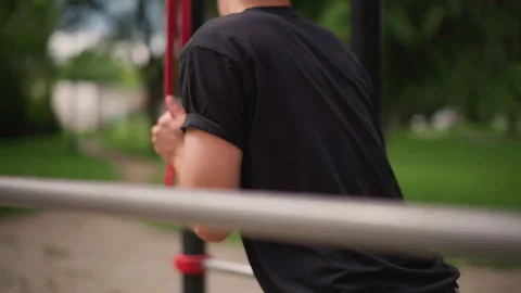 White Man Pausing At Outdoor Pullup Station Holding Red Resistance Band, Back Stock Footage 324756631