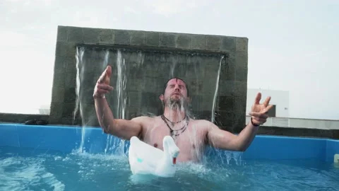 A white man playing with a pool in a pool in a beach house in the day in 4k Stock Footage 173507318