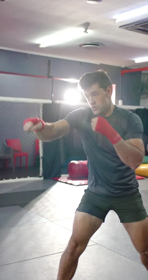 White man practicing shadow-boxing on red mat at crossfit gym following partner Stock Footage 344850287