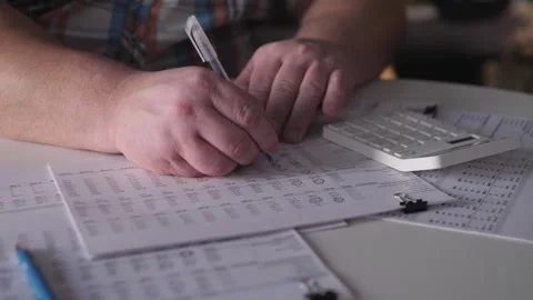 White Man Preparing Quarterly Report With Calculator Charts And Pen On Desk Stock Footage 327336174