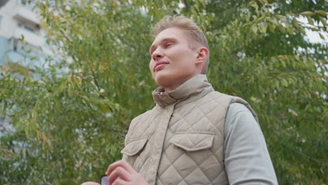 White Man Proposes with Warm Smile as Leaves Sway in Outdoor Urban Scene Stock Footage 305794533