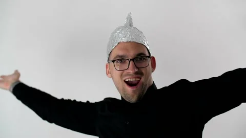 White man puts on a foil hat and joyfully smiles. Stock-Footage 131714184