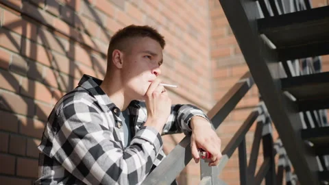 White man resting on railing smoking with lighter and cigarette pack Stock Footage 307052226