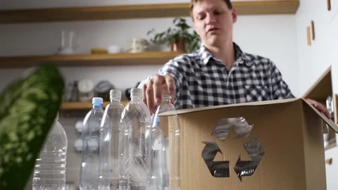 A white man stacks plastic bottles for recycling recycling reuse, plastic ga Stock Footage 201438609