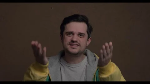 A white man with a surprised expression against a brown wall, showcasing ac.. Stock Footage 300075312