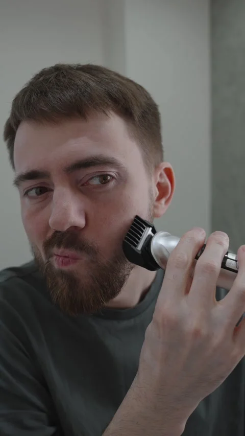 White man trimming beard with electric trimmer startup founder grooming 動画素材 333332075