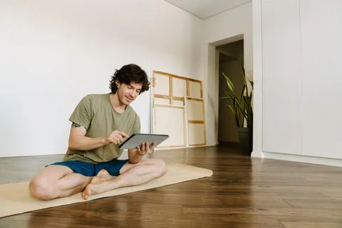 White man using tablet computer during yoga practice Foto stock