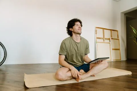White man using tablet computer during yoga practice Foto stock
