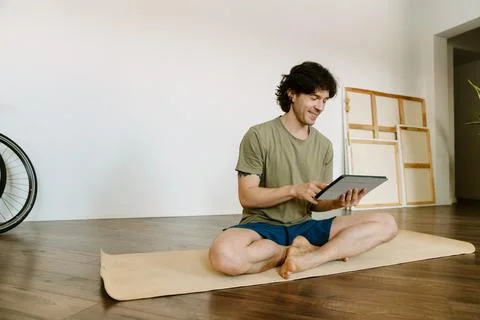 White man using tablet computer during yoga practice Foto stock