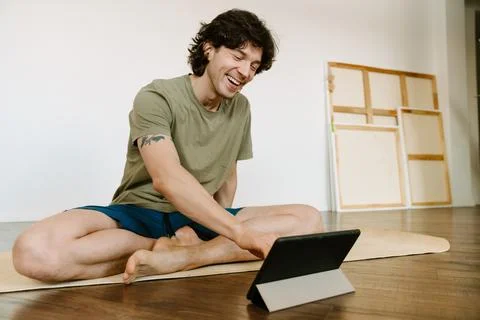 White man using tablet computer during yoga practice Foto stock