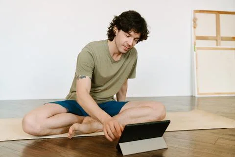 White man using tablet computer during yoga practice Foto stock