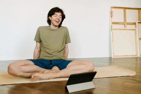 White man using tablet computer during yoga practice Foto stock