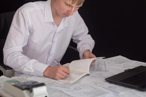White man working in an office with documents. The Manager makes the report a Stock Photos