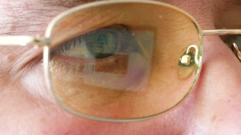 The white man's eye macro. The glasses reflect the computer monitor. 스톡 동영상 133634938