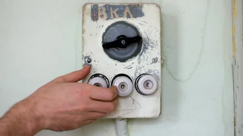 White man's hand to replace outdated ceramic fuse on an old scratched switchboar Stockbeeldmateriaal 62400921